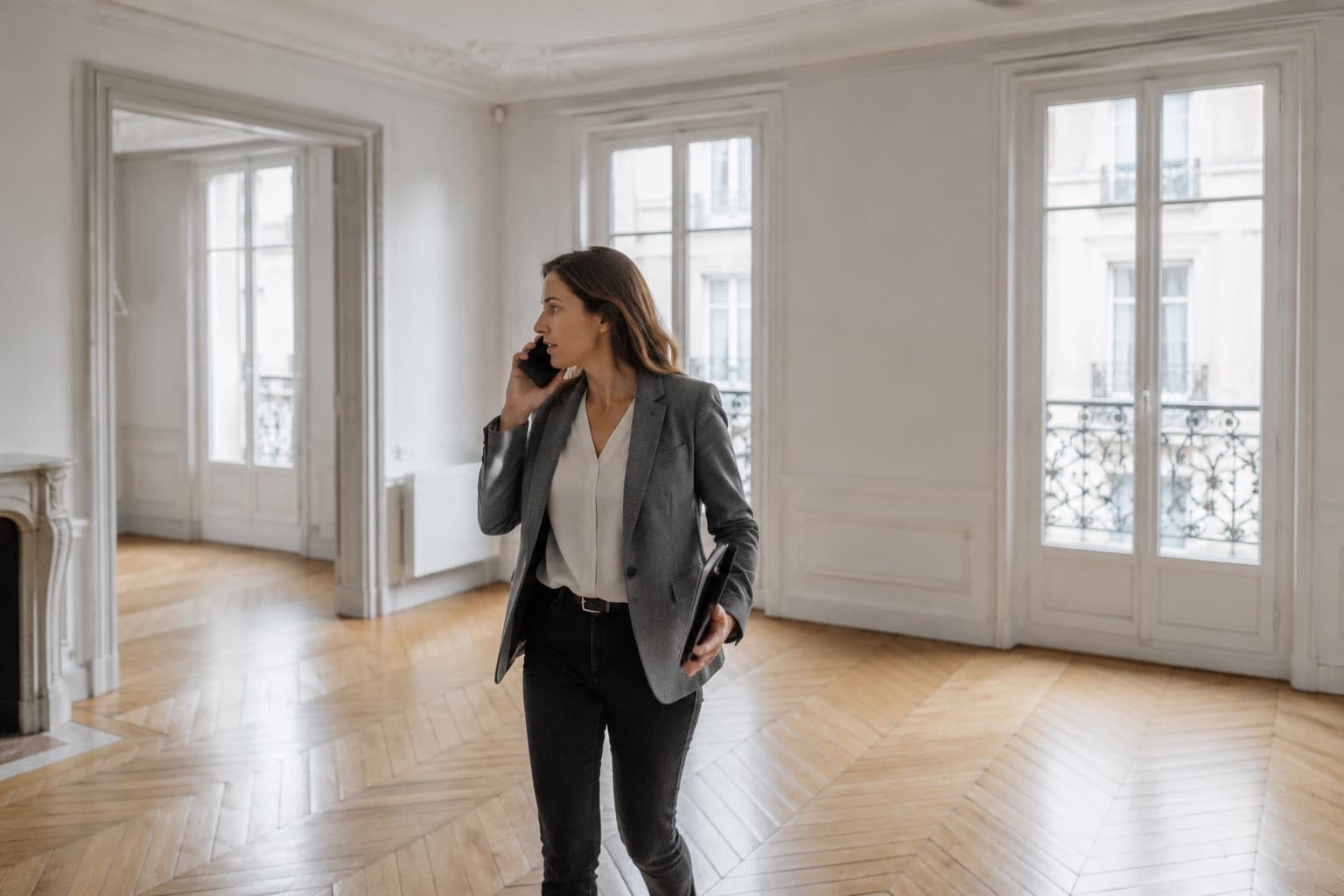 Une agente immobilière dicte sa fiche en visitant un appartement vide